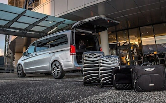 Van with open trunk and luggage at Sharm El Sheikh airport transfer area.