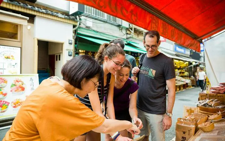 Tourists exploring food stalls at Tokyo Tsukiji Outer Market.