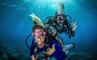 Scuba divers exploring underwater in Fujairah with instructor guidance.