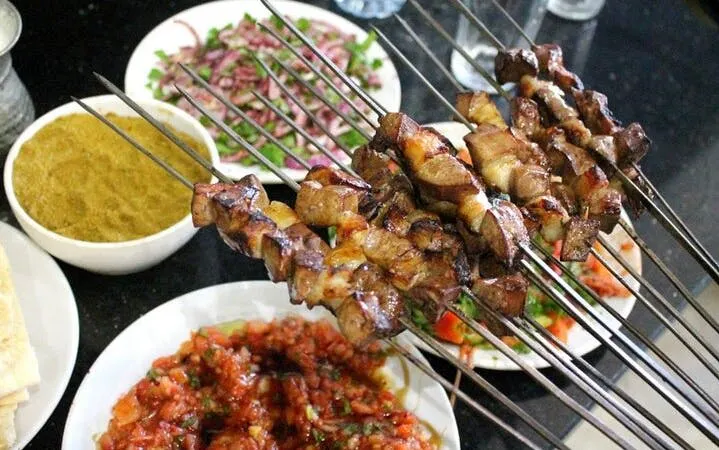 Grilled kebabs with traditional Turkish dishes on a table during a cultural tour in Eastern Turkey.