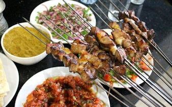Grilled kebabs with traditional Turkish dishes on a table during a cultural tour in Eastern Turkey.
