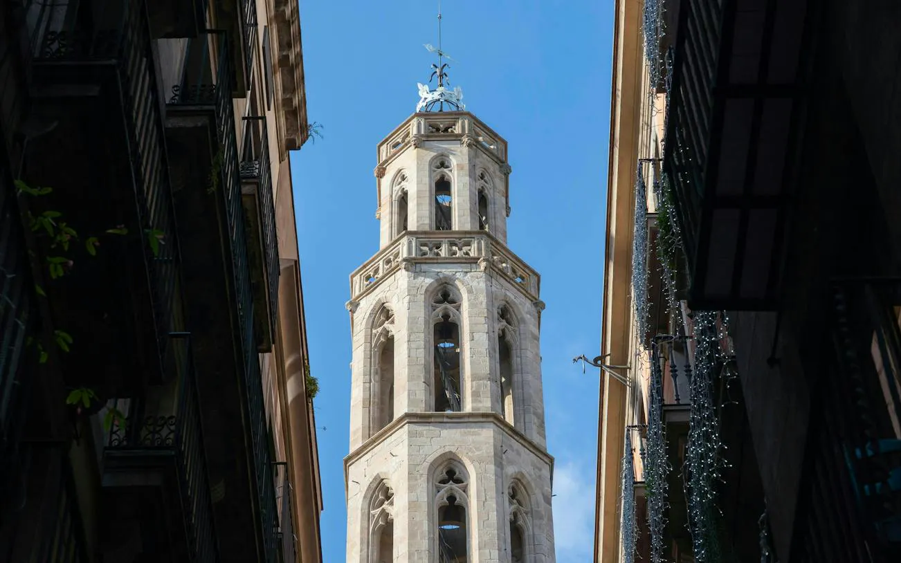 Santa Maria del Mar bell tower between narrow streets in El Born, Barcelona.