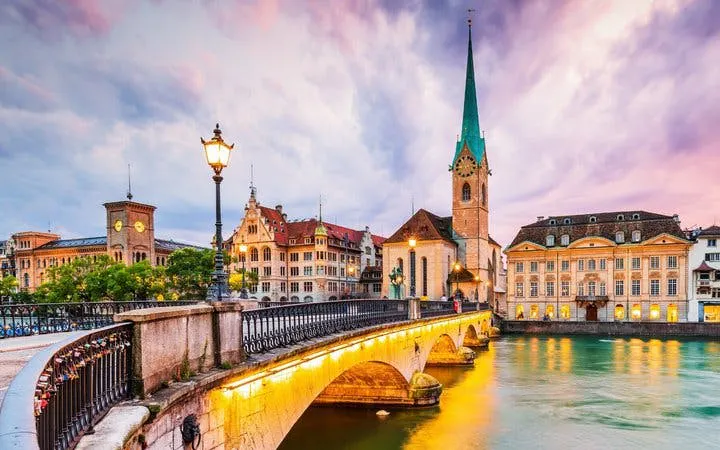 Zurich's Fraumünster Church and bridge at sunset on self-guided walking tour.