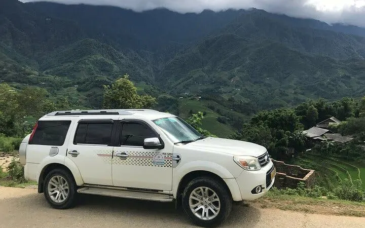 Private car parked with view of Sapa mountains, Vietnam, for transfer to Ha Noi.