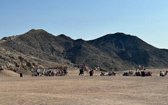ATV quad bike safari group at sunset near mountains in Sharm El Sheikh desert.