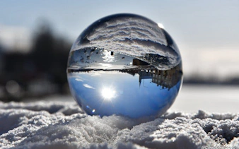 Reykjavik skyline reflected in a glass sphere on snow during a guided walking tour.