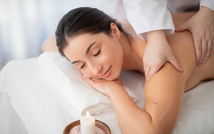Moroccan hammam massage in Marrakesh spa setting with candle.