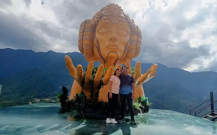 Couple at Moana sculpture viewpoint, Sa Pa, with mountain backdrop.