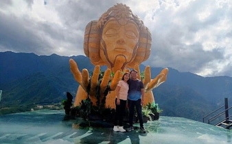 Couple at Moana sculpture viewpoint, Sa Pa, with mountain backdrop.