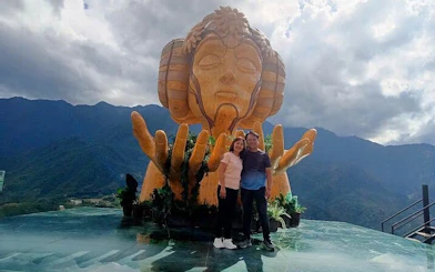 Couple at Moana sculpture viewpoint, Sa Pa, with mountain backdrop.