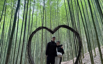 Couple standing in bamboo forest with heart-shaped frame, Mu Cang Chai motorbike tour.