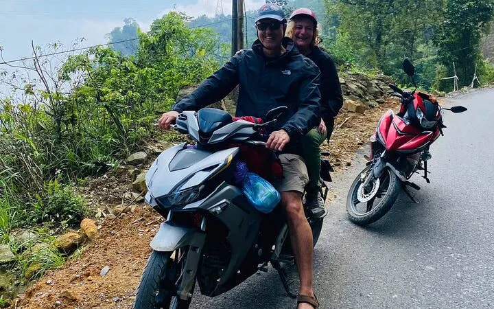 Motorbike riders on a scenic road in Sapa's hidden valleys, Vietnam.