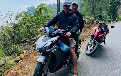 Motorbike riders on a scenic road in Sapa's hidden valleys, Vietnam.