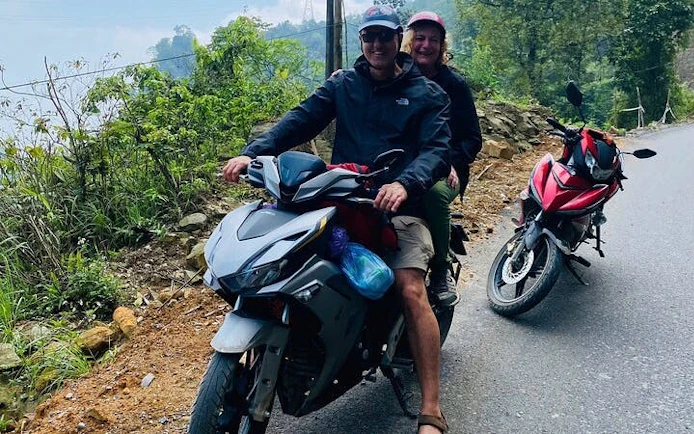 Motorbike riders on a scenic road in Sapa's hidden valleys, Vietnam.