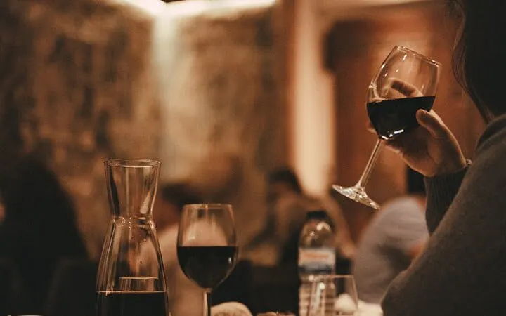 Wine glass and carafe on table at Fado Midnight Open Mic, Mesa de Frades.