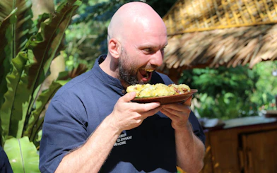 Man enjoying food at Samui Elephant Home Nursery feeding program.