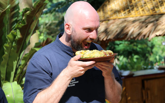 Man enjoying food at Samui Elephant Home Nursery feeding program.