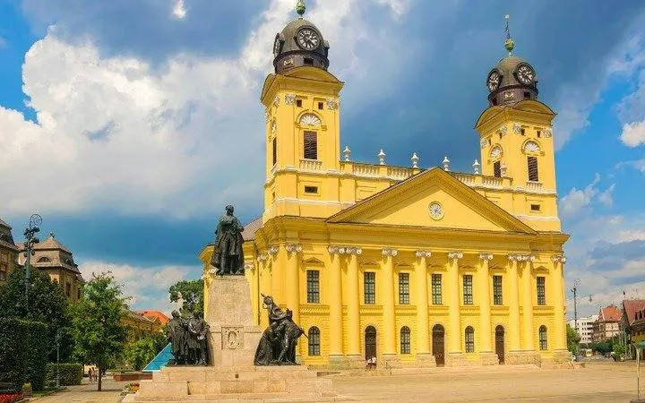 Reformed Great Church in Debrecen with Kossuth Square statues, part of self-guided audio tour.