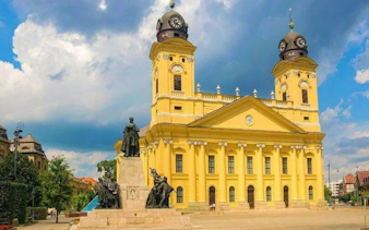 Reformed Great Church in Debrecen with Kossuth Square statues, part of self-guided audio tour.