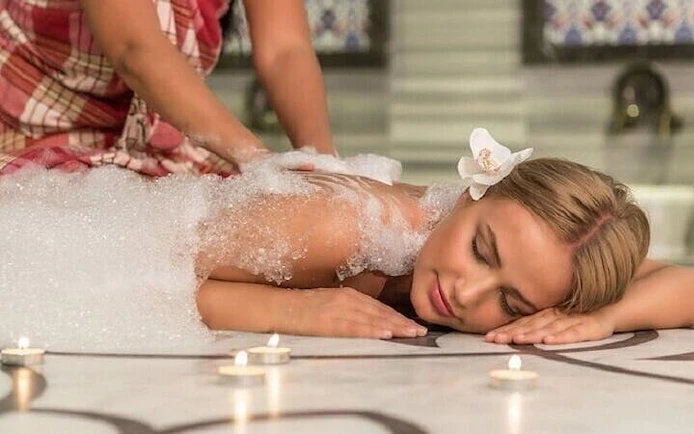 Moroccan Hammam massage with bubbles at historic Marrakesh bathhouse.