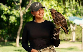 Person holding a bird of prey at wildlife conservation area, Punta Cana.