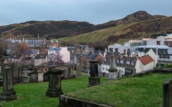Edinburgh cityscape with historic cemetery and hills in the background on a self-guided walking tour.