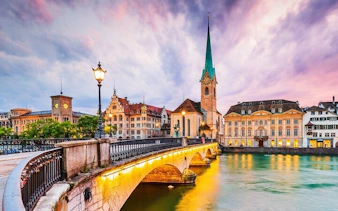 Zurich's Fraumünster Church and bridge at sunset, part of Einstein's city exploration game.