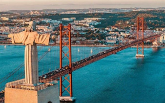 Christ the King statue overlooking 25 de Abril Bridge in Lisbon.