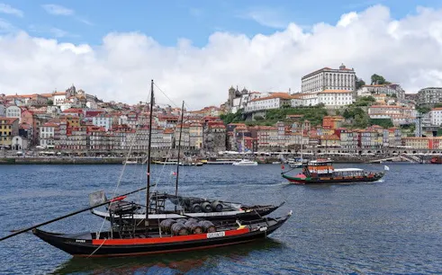 Porto riverside view with traditional boats and historic buildings in the background.