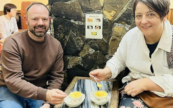 Tourists enjoying egg coffee at a café in Hanoi's Old Quarter during a cyclo tour.