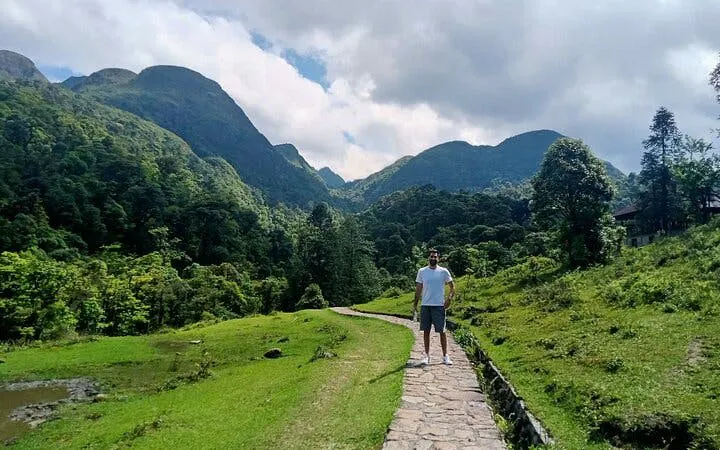 Sapa mountain path with traveler, lush greenery, and distant peaks.