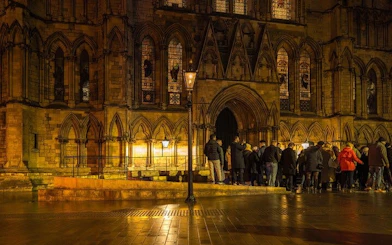 York walking tour group outside historic cathedral at night.