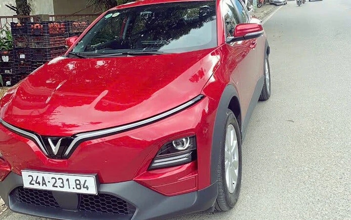 Red car parked on street for private museum tour rental service.