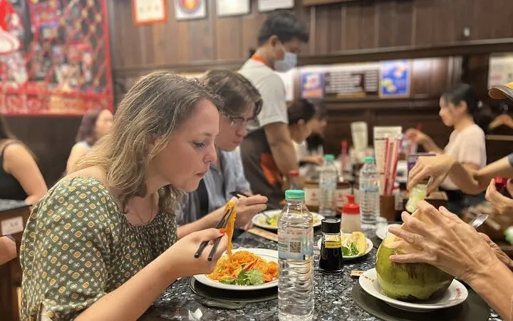 Tourists enjoying a meal at a Michelin-recognized restaurant in Bangkok during a food tour.