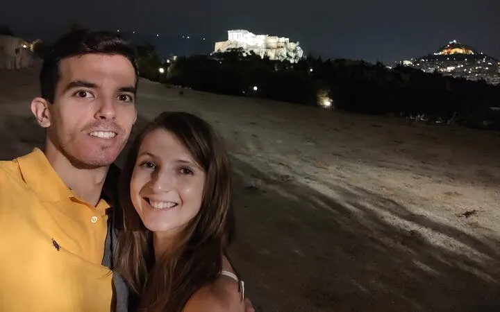 Couple at night with Acropolis view in Athens, Greece.