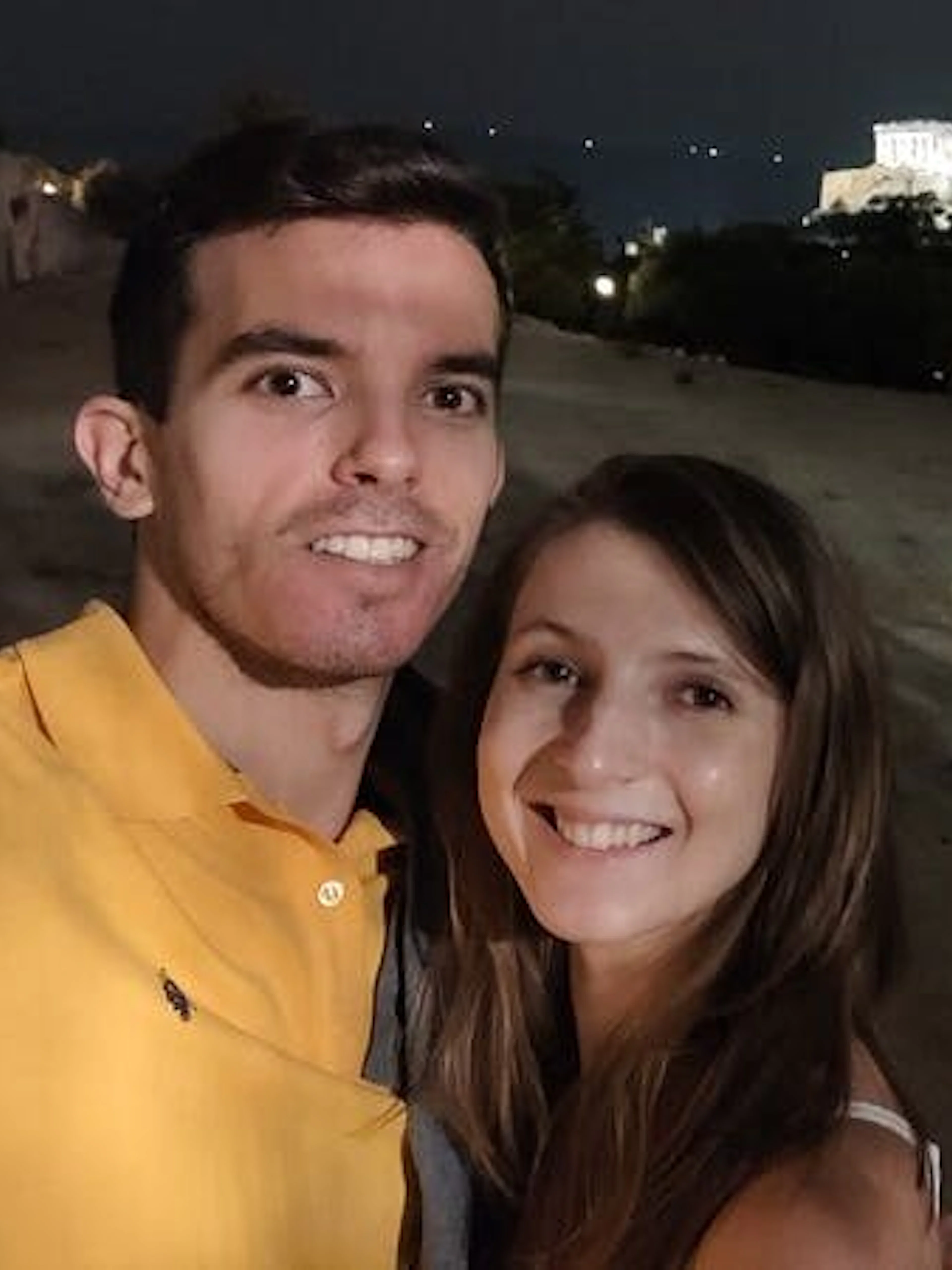 Couple at night with Acropolis view in Athens, Greece.