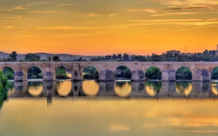 Roman bridge over the Guadalquivir River at sunset in Córdoba, Spain.