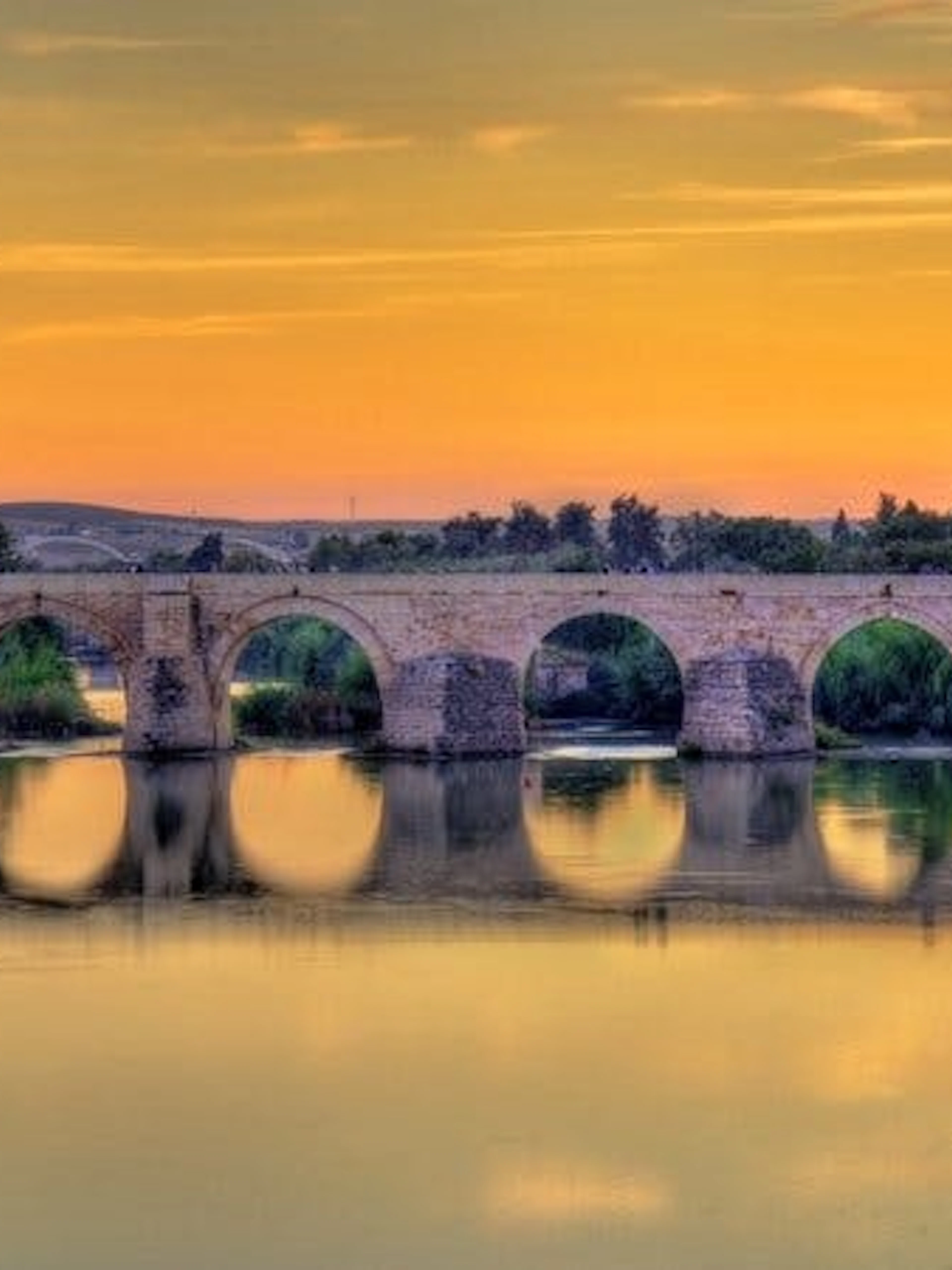 Roman bridge over the Guadalquivir River at sunset in Córdoba, Spain.