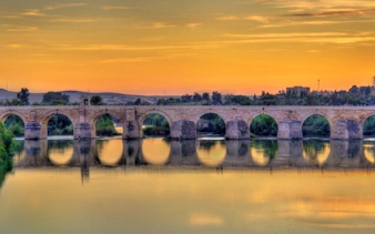 Roman bridge over the Guadalquivir River at sunset in Córdoba, Spain.