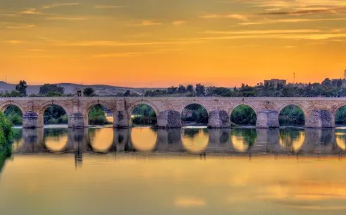 Roman bridge over the Guadalquivir River at sunset in Córdoba, Spain.