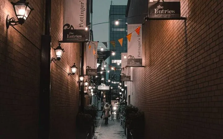 Narrow Melbourne alleyway with hanging lights and banners, part of self-guided city exploration game.
