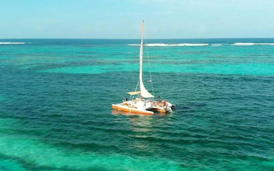 Catamaran sailing in turquoise waters, Punta Cana, with passengers enjoying the view.