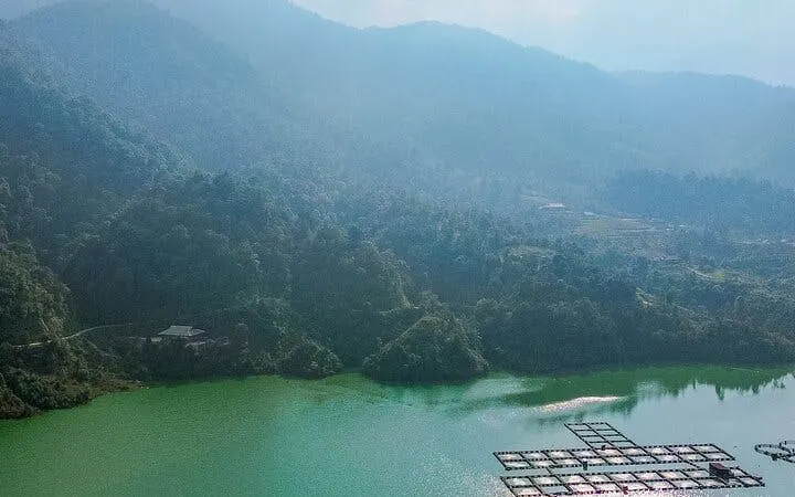Sapa mountain landscape with green lake and floating platforms, Vietnam.