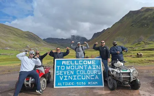 ATV riders at Rainbow Mountain, Vinicunca sign, Cusco tour.