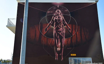 Reykjavik mural of a floating figure on a building during street art walking tour.
