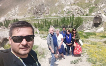 Group exploring Cappadocia's hidden sites with rock formations in the background.
