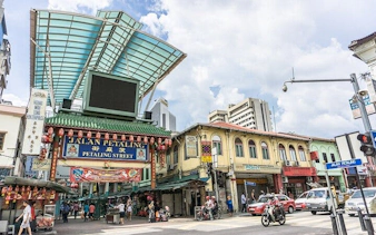 Jalan Petaling entrance in Kuala Lumpur, bustling street scene with shops and people.