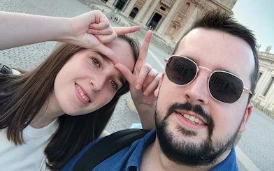 Two people posing in front of a historic building in Rome during a self-guided city exploration game.