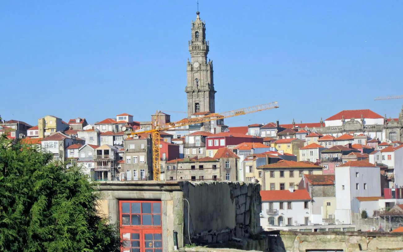 Clérigos Tower overlooking colorful buildings in Porto's historic center.