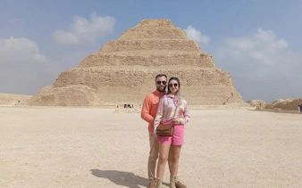 Couple in front of the Step Pyramid of Djoser, Egypt, during a guided tour.